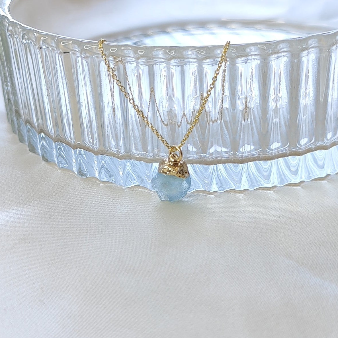 Necklace with a blue pendant on a white surface