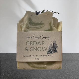 Artisan soap with 'Huron Soap Company Cedar & Snow' packaging on a gray background