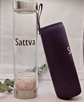 Clear glass water bottle with metal cap and black sleeve featuring 'Sattva' branding on a white background.