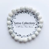 White beaded bracelet with 'Sattva Collections' branding on a light gray background