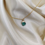 Necklace with a green pendant on a beige fabric background