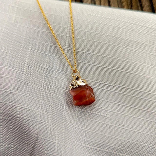 Necklace with a red pendant on a textured surface