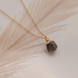 Necklace with a brown stone pendant on a light background