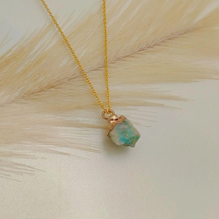 Necklace with a green stone pendant on a light background