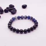 Beaded bracelet with blue and black beads on a white background