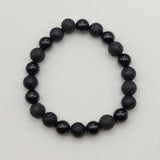 Black beaded bracelet on a light gray background