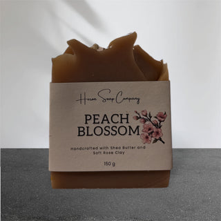 Artisan soap with 'Huron Soap Company Peach Blossom' label on a gray background