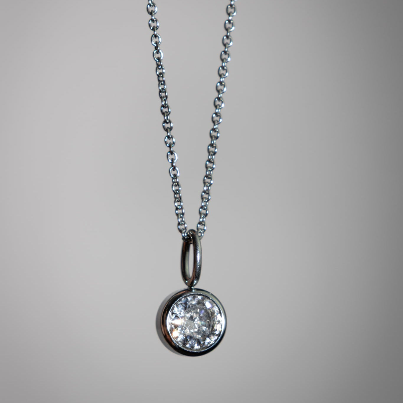 Diamond pendant necklace on a gray background