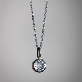 Diamond pendant necklace on a gray background